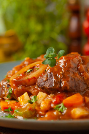 Ossobuco served with stewed vegetables. Colorful background. Gray plate.の写真素材