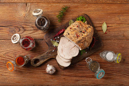 Crispy, cooked ham. Served with spices on a wooden board. Top view.の写真素材