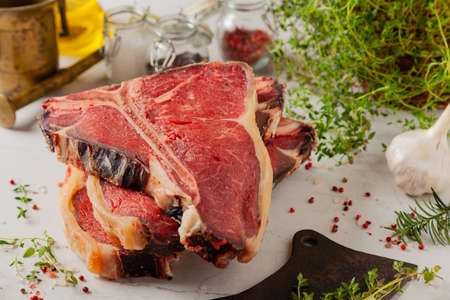 Raw t bone steak, with herbs. Stone bright backgroundの写真素材