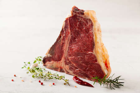 Raw t bone steak, with herbs. Stone bright backgroundの写真素材