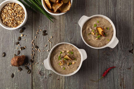 Soup, Jerusalem artichoke cream. Served with croutons in gray bowls. Wooden background.の写真素材