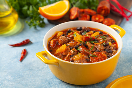 Pork stew with chorizo and black beans. Served with orange and seasoned with hot chili peppers. Perfect with tortillas.の写真素材