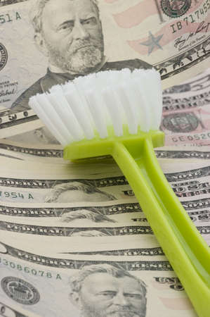 Brush lying on dollar banknotes, symbolisingmoney-laundering and illegal financial operations.の写真素材