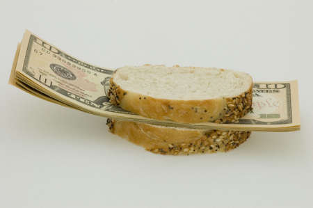 Sandwich with money, symbolising decrease in standard of living and inflation.の写真素材