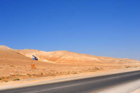 Israel Flag Near Empty Highway In Jordan Valley.の写真素材