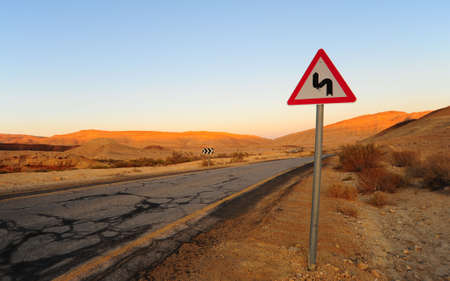 Dangerous Curves Road Sign At The Abandoned Road. Sunsetの写真素材