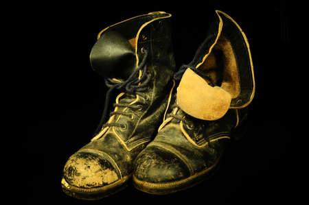Pair of Old, Well Worn, Military Boots on Black Background.の写真素材