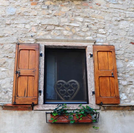 Typical Italian Window With Open Wooden Shutters, Decorated With Fresh Flowersの写真素材