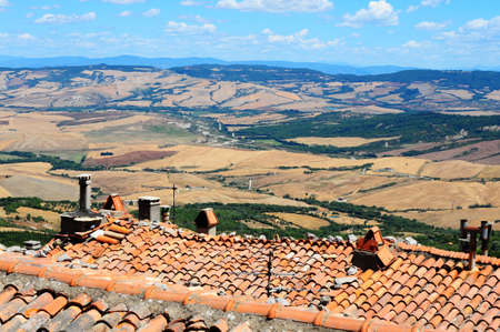 Old Broken Tile Roof Against Tuscan Landscapeの写真素材