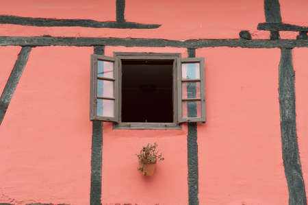 Pink Wall Spanish House with Wooden Beams and an Open Windowの写真素材