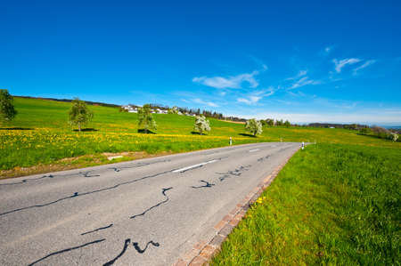 Asphalt Road Leading to the Farmhouse in the Swiss Alpsの写真素材