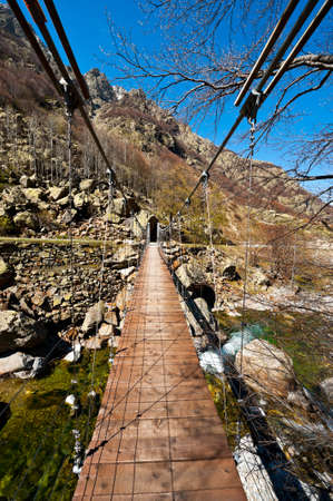 Cable-Stayed Bridge across Mountain Stream in the Italian Alps, Piedmontの写真素材