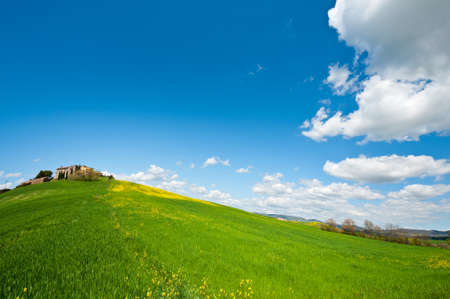 Farmhouse and Green Sloping Meadows of Tuscanyの写真素材