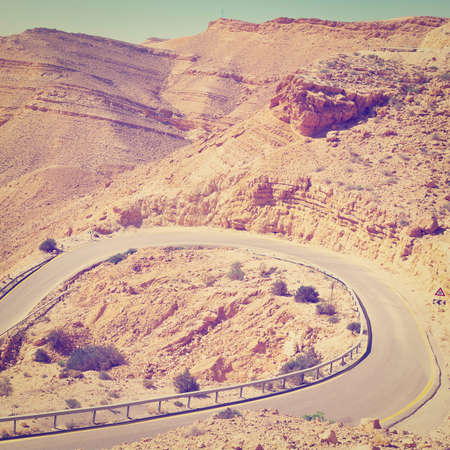 Winding Asphalt Road in the Negev Desert in Israel, Retro Effectの写真素材