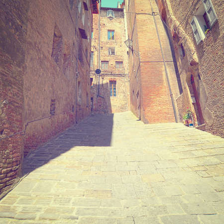 Narrow Alley with Old Buildings in Italian City of Siena.の写真素材