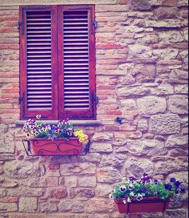 Italian Window with Closed Wooden Shutters, Decorated with Fresh Flowers.の写真素材