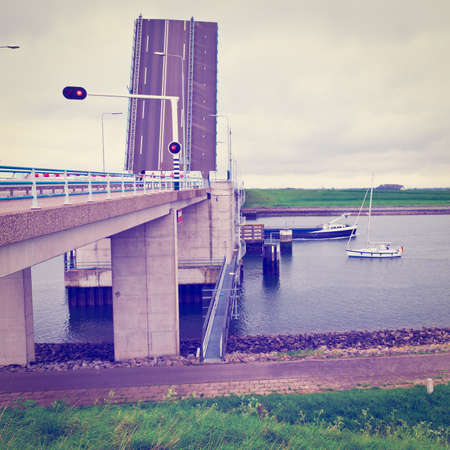 Yacht and Barge Float under the Drawbridge on the Channel in Holland,の写真素材