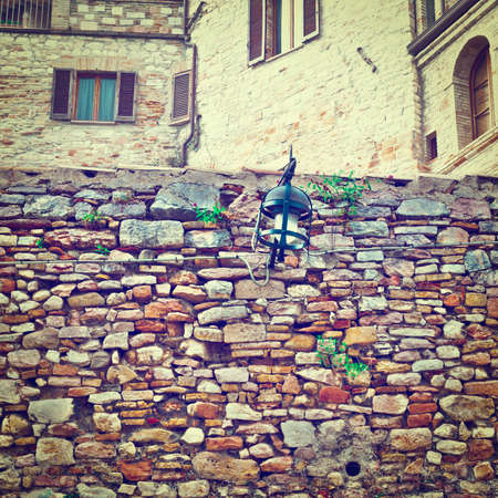 Old Wall on the Background of the Buildings in the Italian Medieval Cityの写真素材