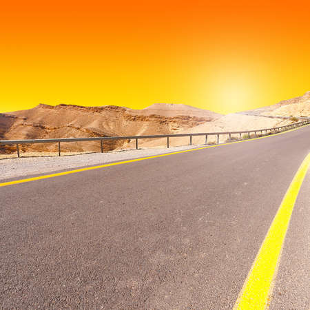 Meandering Road in Sand Hills of Judean Mountains at Sunsetの写真素材