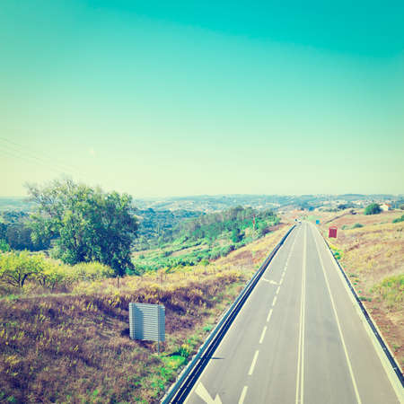 Straight Asphalt Road between Hills in Portugalの写真素材