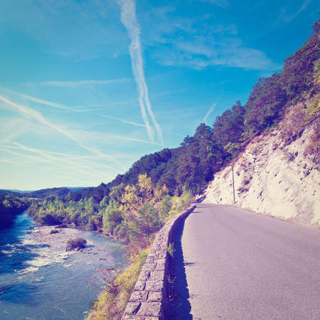 asphalt road along the river bank in french alpsの写真素材