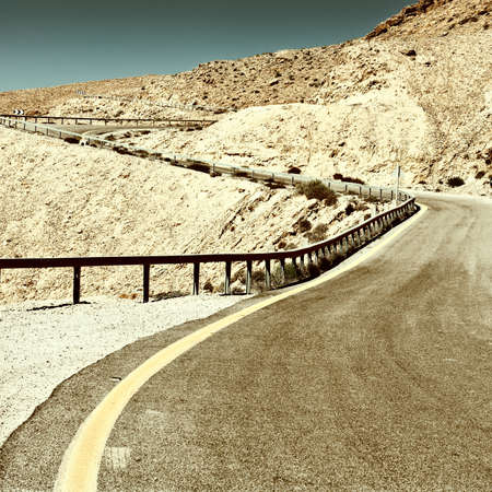 Winding Asphalt Road in the Negev Desert in Israel, Retro Image Filtered Styleの写真素材