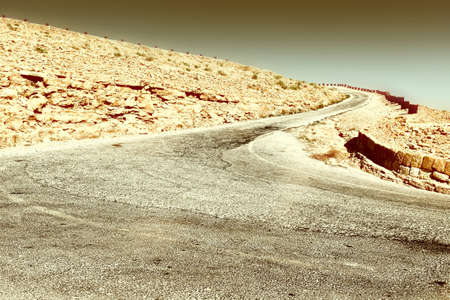 Meandering Road in Sand Hills of Judean Mountains, Israel, Retro Image Filtered Styleの写真素材