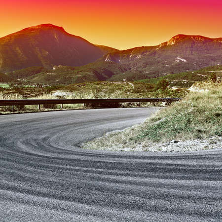 Winding Paved Road in the French Alps at Sunset, Vintage Style Toned Pictureの写真素材