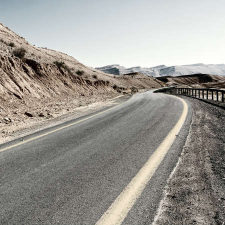 Winding Asphalt Road in the Negev Desert in Israel, Vintage Style Toned Pictureの写真素材