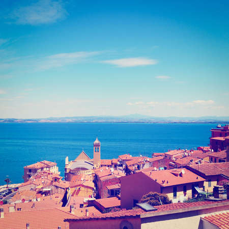 view of the harbor  porto san stefano from tiled roofsの写真素材