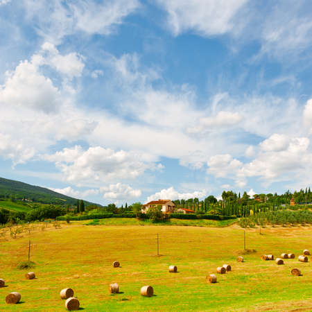 Tuscany Landscape with Many Hay Bales on the Background of the Italian Villageの写真素材