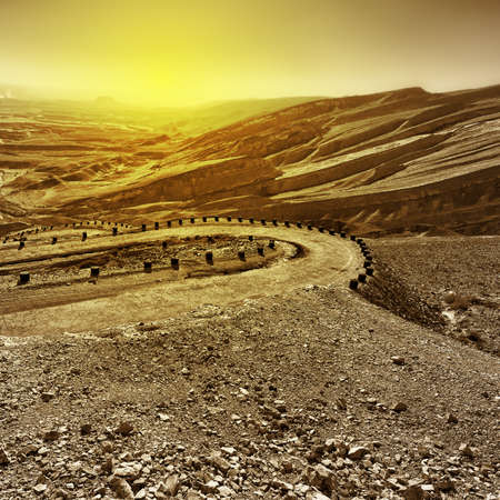 Meandering Road in Sand Hills of Judean Mountains at Sunsetの写真素材