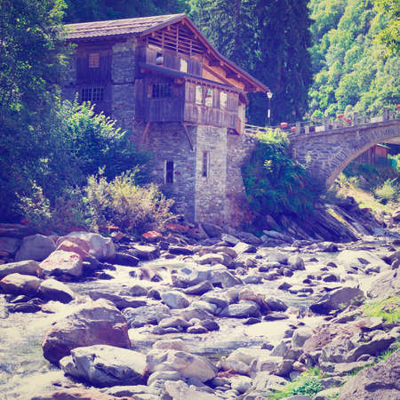 Medieval City on the Shore of a Mountain River in Italian Alps  の写真素材
