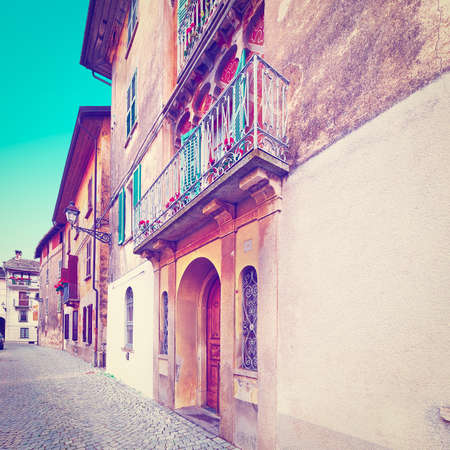 narrow street with old buildings in italian city in piedmontの写真素材