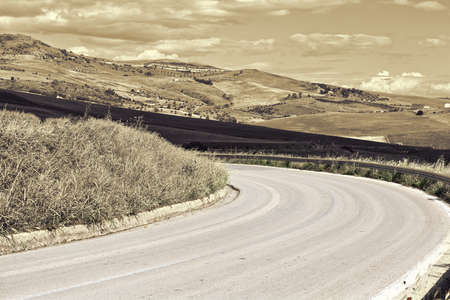 Winding Asphalt Road between Stubble Fields of Sicily, Retro Image Filtered Styleの写真素材