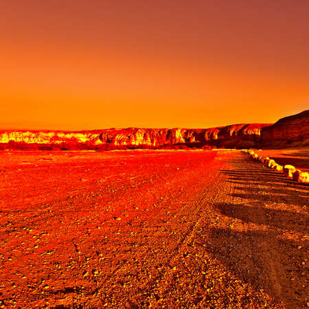 Dirt Road of the Negev Desert in Israel at Sunset, Vintage Style Toned Pictureの写真素材