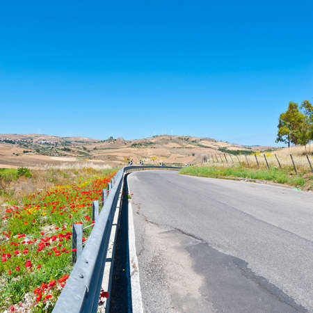 Winding Asphalt Road on the Background of the Modern Wind Turbines in Sicilyの写真素材