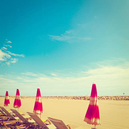 Beach Umbrella and Sun Bed in the Low Season of the French Riviera, Vintage Style Toned Pictureの写真素材