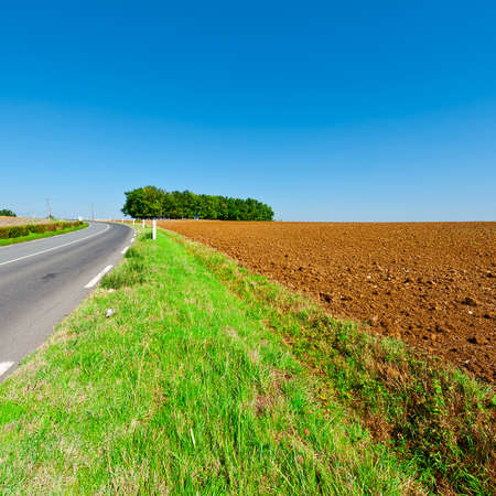 Winding Asphalt Road between Autumn Plowed Fields in France, Vintage Style Toned Picture