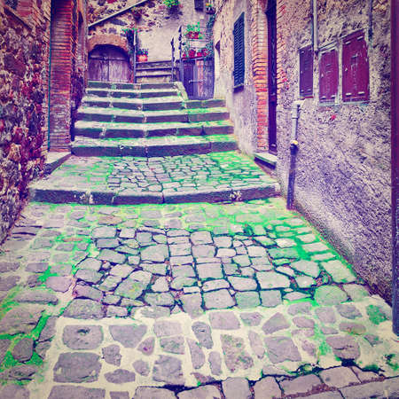 Narrow Alley with Old Buildings in Italian City of Torre Alfinaの写真素材