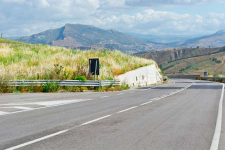 Asphalt Road between Stubble Fields of Sicilyの写真素材