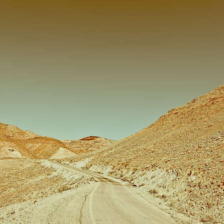 Winding Asphalt Road in the Negev Desert in Israel, Vintage Style Toned Pictureの写真素材