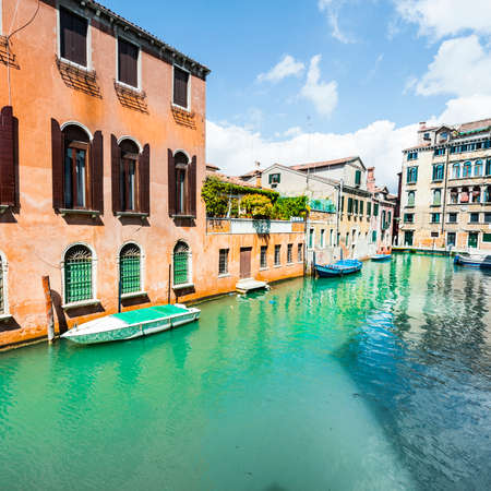 Houses peeling off from dampness. Venice is situated across a group of islands that are separated by canals and linked by bridges. Gondola is a traditional, flat-bottomed Venetian rowing boatの写真素材