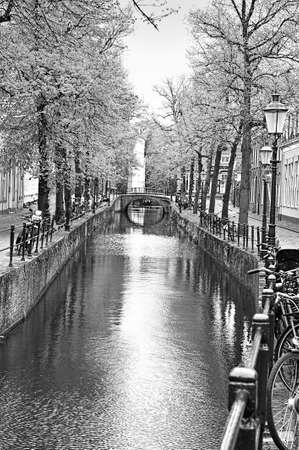 Urban scene in Amersfoort with typical local architecture and many bicycles. Street View with bikes parked on an embankment in the historical center of Amersfoort in the Netherlands. Black and white pictureの写真素材
