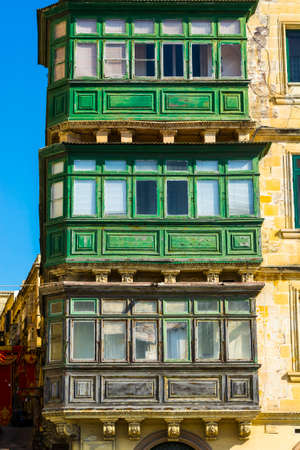 Building with traditional colorful maltese balcony in historical part of Valletta. Windows on the facade of a house in Maltaの写真素材