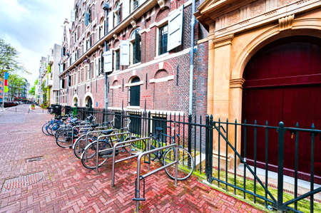 Typical Dutch brick houses in Holland. Street View with bikes parked in the historical center of Amsterdam in the Netherlandsの写真素材