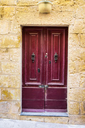 Building with traditional maltese door in historical part of Valletta. Entrance to an abandoned house on the island of Maltaの写真素材