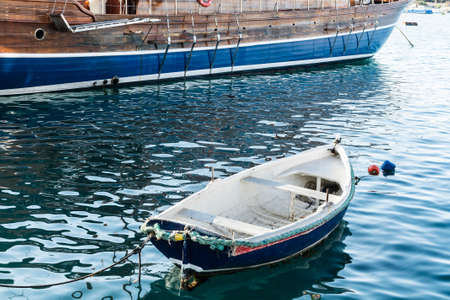 Yachts docked at the port of Malta. A shabby old boat among the luxury shipsの写真素材