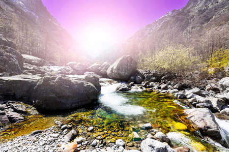 Morning mist over the stream in the Italian Alps in Piedmont. View of the mountain valley with river at sunriseの写真素材