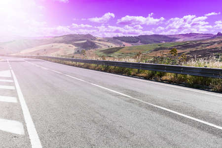 Landscape of Sicilian hills at sunrise. Asphalt road elevated by columns due of frequent earthquakes of the island of Sicilyの写真素材